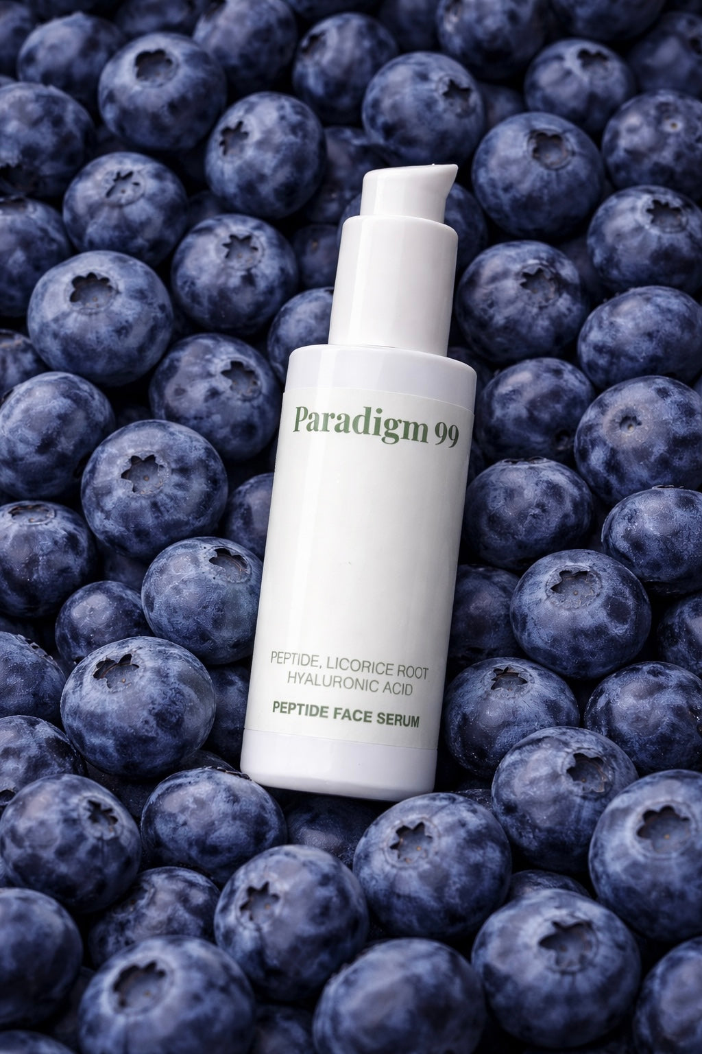 Paradigm 99 peptide face serum bottle on a bed of blueberries